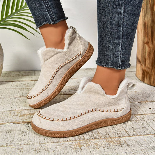 Milky white fleece-lined slip-on ankle booties, worn