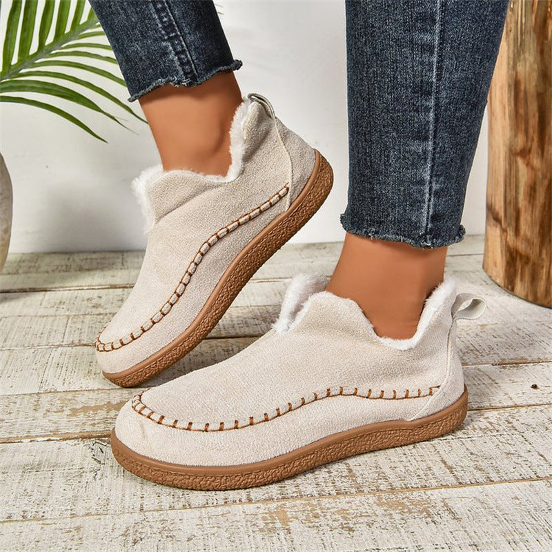 Milky white fleece-lined slip-on ankle booties, worn