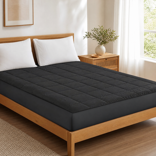 Embossed quilted fitted mattress pad on a bed in a bright bedroom