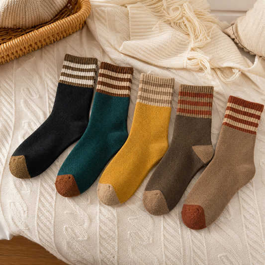 Thick warm winter socks laid out on a knit blanket
