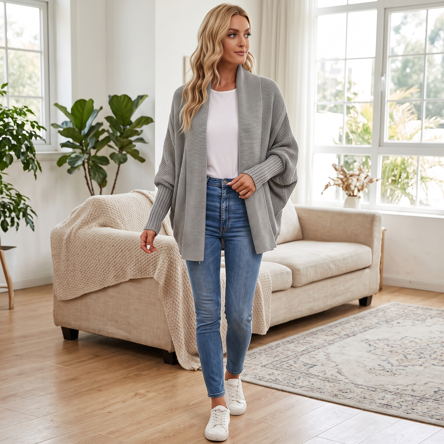 Woman wearing the grey batwing knit cardigan in a bright living room