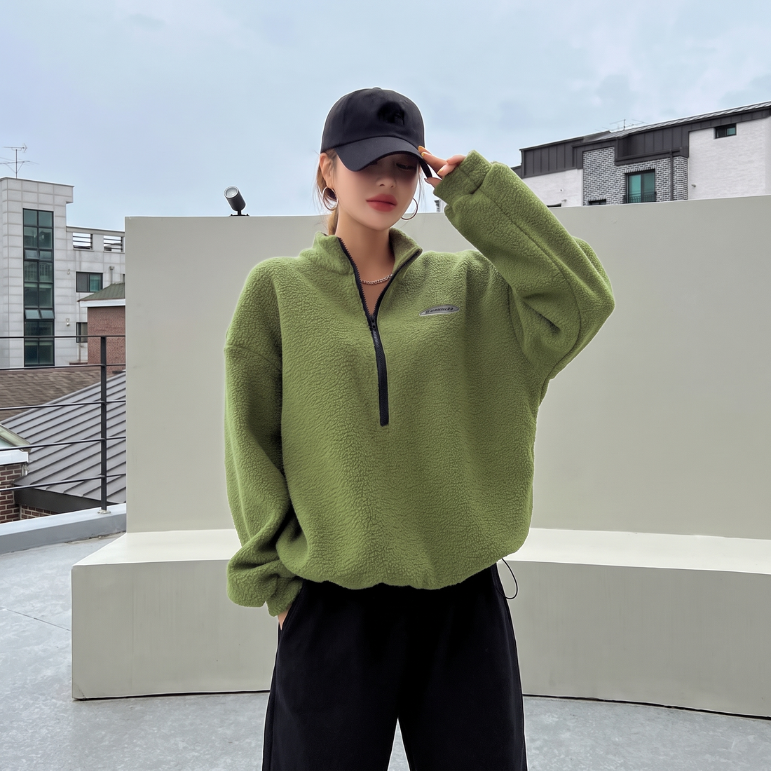 Lime green half zip fleece pullover worn with a cap